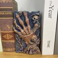 Detailed view of gothic resin skull hand bookend with intricate skeletal carvings. - Five-Finger Style