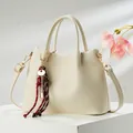 Crèmekleurige lederen handtas met kiezelnerf en elegante sleutelhanger accessoire. - 25*9*18 / Broken Wit