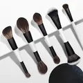 Close-up van dubbelzijdige zwart-witte make-up kwasten op geometrische witte blokken. - 5-delige Zwart-Witte Dubbelzijdige Borstels