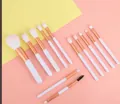 12-piece makeup brush set with white handles and rose gold ferrules on a pink background - 12 Makeup Brushes Pink