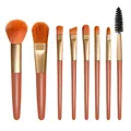 Primo piano di 8 pennelli da trucco professionali con setole arancioni su sfondo bianco - Set da 8 pezzi / Arancione