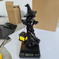 Detailansicht der Hexenstatue aus Harz mit LED-Laterne auf einer Waage zur Gewichtsprüfung - Schwarze Hexenlaterne