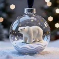 Clear glass Christmas ornament ball with polar bear figurine and gold stars on snow - Polar Bear