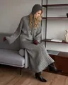 Model wearing a grey ribbed knit sweater and long skirt set in a modern home interior. - M / Set / Gray