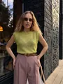 Model wearing a lightweight lime green sleeveless knit vest with a round neck - S / Tops / Green