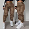 Stylish women's brown faux leather cargo pants featuring pockets and pleated biker details - S / Brown