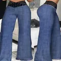 Detalle de los pantalones de campana de talle alto con cinturilla elástica negra calada. - Azul Denim