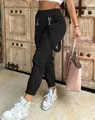 Detailed view of high-waisted black cargo pants with strap and metal ring accents. - S / Bottoms / Black