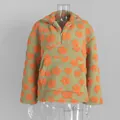 Detailansicht des flauschigen Fleece-Stoffs mit orangefarbenem Blumenmuster auf einem Hoodie - S / Oberteile / Grasgrün mit orangefarbenen Blumen