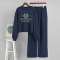 Detailed view of navy blue two-piece lounge set with gold embroidered sweatshirt and pants - S / Top And Bottom / Navy Blue