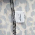 Détail de l'étiquette d'entretien d'un ensemble de pyjama léopard chic. - Style en Mélange de Matières
