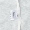 Macro detail shot of a white beachwear care label showing 25% viscose 75% polyester blend - S / Set / White