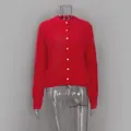 Vista dettagliata del cardigan rosso a maniche lunghe in peluche con bottoni bianchi su manichino - Taglia S / Top (MY02773) / Rosso