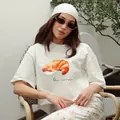 Γυναικείο λευκό υπερμέγεθες βαμβακερό T-shirt με ρεαλιστική γραφική εκτύπωση κρουασάν - S / Tops / Λευκό