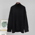 Vollansicht eines schwarzen, locker sitzenden Strick-Rollkragenpullovers an der Wand - S / Oberteile / Schwarz