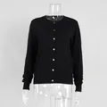 Detailed macro view of a black button-down knit cardigan sweater on a clear mannequin - S / Tops / Cardigans / Black