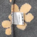 Macro detail of washing label showing 100% polyester composition on floral fleece - S / Tops / Gray with Yellow Floral