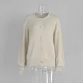 Detailansicht eines beigen einreihigen Strick-Cardigans mit Zierknöpfen auf einer Schaufensterpuppe - S / Oberteile / Beige