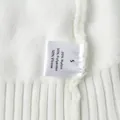 Close-up of white knit sweater care label showing material blend and size S information - M / Top And Bottom / Off White