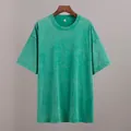 Close-up view of a vintage washed green cotton T-shirt showing distressed texture. - Grass Green