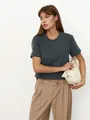 Model trägt ein dunkelgraues kurzärmliges T-Shirt mit Rundhalsausschnitt und beige Hose - S / Oberteile / Blaugrau