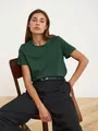 Detailansicht eines dunkelgrünen Damen-T-Shirts mit Rundhalsausschnitt und schwarzer Hose - Dunkelgrün