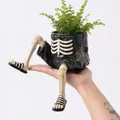 Vue détaillée d'un pot de fleurs suspendu en forme de squelette d'Halloween. - Jambes de Squelette