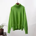 Gemütlicher hellgrüner übergroßer Rollkragenstrickpullover an einem schlichten Hintergrund - Obstgrün