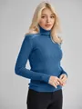 Detailansicht des blauen Rollkragenpullovers mit Rippstrick an einem blonden Model. - Einheitsgröße / Oberteile / Denim-Blau