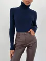 Detail eines dunkelblauen Rollkragenpullovers kombiniert mit brauner Kunstlederhose - Einheitsgröße / Oberteile / Saphirblau