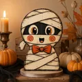 Macro view of the hand-painted wooden mummy character with orange eyes and bow tie - Mummy (C)