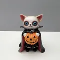 Primer plano de una figura de gato de resina disfrazado de vampiro con una calabaza - Gato Vampiro con Calabaza