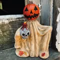 Macro view of a Halloween resin pumpkin wizard figurine holding a skull and candle - Yellow Cloak Pumpkin Head / Yellow