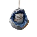Vue détaillée d'une figurine de hibou nichée dans un ornement en géode de cristal bleu. - Hibou Blanc
