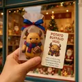 Close-up detail of a cute Christmas buffalo hug figurine in a mesh gift bag with card - Style B Buffalo
