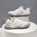 Close-up side view of grey and white breathable flyknit outdoor hiking shoes for trekking - 38 / White