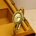 Luxuriöse SUNLIFEX Damen-Armreif-Uhr in Gold mit ovaler Form und funkelnder Strass-Lünette. - Strass Eingelegt Gold-Gold Stil