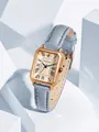 Gros plan d'une montre rectangulaire vintage dorée avec un bracelet en cuir bleu clair - Bleu ciel