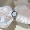 Primo piano di un elegante orologio in maglia d'argento con castone di strass su pizzo bianco - Quadrante Ovale / Argento (Cinturino Argento Quadrante Argento)