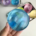 Balle anti-stress en huile de coco bleue translucide tenue dans la main pour relaxer - Balle à l'Huile de Coco Haute Translucide / Bleu