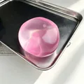 Jouet anti-stress rose translucide à l'huile de coco sur un plateau en acier inoxydable - Balle à l'Huile de Coco Haute Translucide / Rose