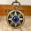 Primo piano di orologio da taschino retrò in bronzo con gemma blu e coperchio a stella. - zircone blu