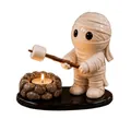 Detail einer niedlichen Mumienfigur beim Rösten von Marshmallows über dem Teelichthalter - Mumien-Lagerfeuer / Kerzenhalter