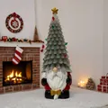 Detailed view of resin Christmas gnome figurine with LED tree hat on a snowy white surface - Lighted Gnome Christmas Tree