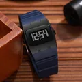 Detailed view of a square digital watch with a navy blue silicone strap - Blue