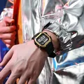Retro square digital sports watch for men featuring a black and gold case on wrist - Gold