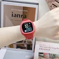 Square pink LED digital watch featuring astronaut cartoon theme shown on a person's wrist - Red