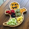 Detail eines geisterförmigen Halloween-Holzbretts, gefüllt mit frischen, bunten Früchten. - Geist-Stil