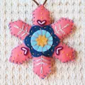 Detailed view of pink and blue handmade felt Christmas snowflake ornament with intricate embroidery - Pink Snowflake (202640) / Pink Material Pack
