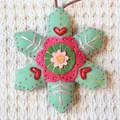 Detailed macro view of a handmade embroidered felt snowflake Christmas decoration - Light Green Material Pack